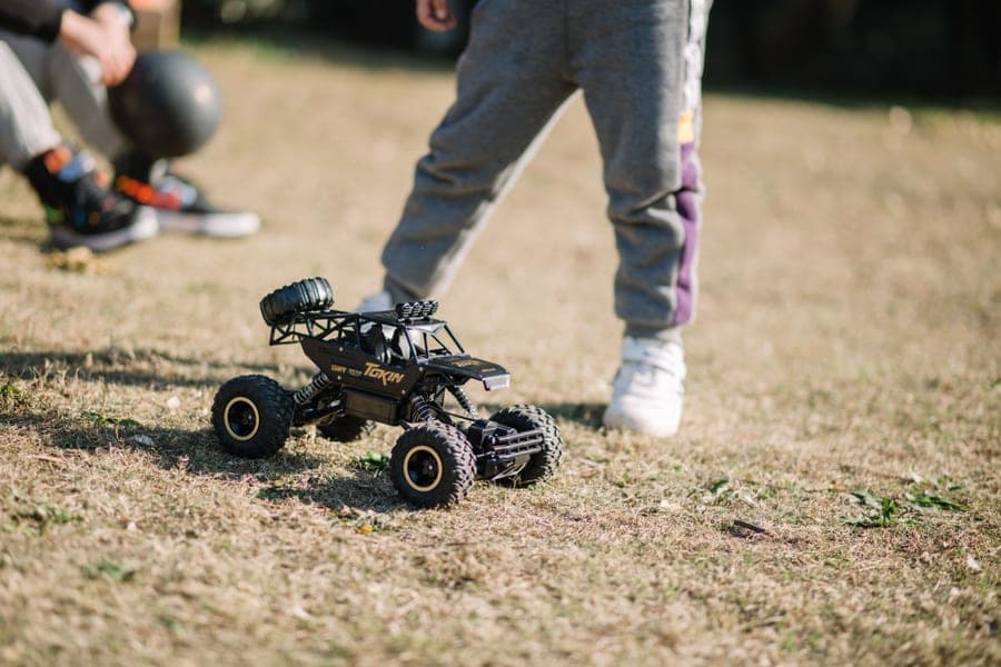 A remote control car being driven across a lawn
