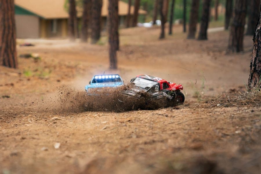 Two RC cars racing along a forest track