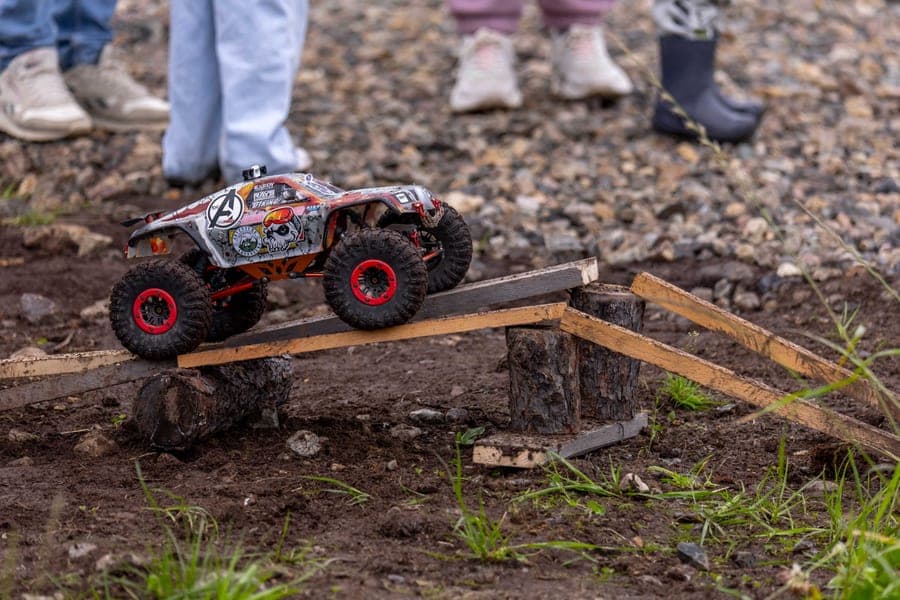 An RC truck climbing over an outdoor obstacle