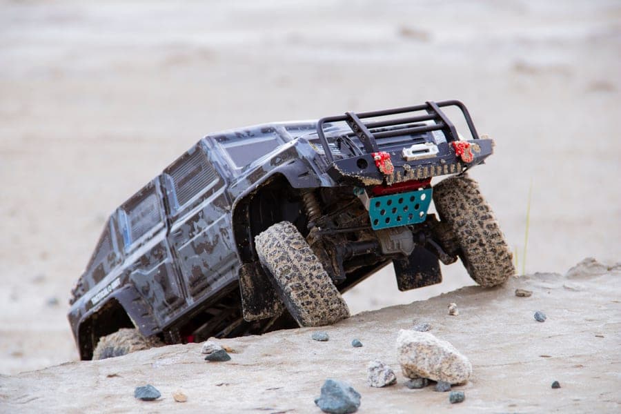 A 1/10-scale RC truck on sandy off-road terrain