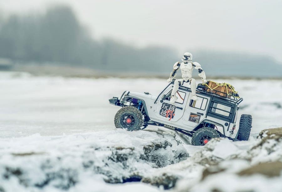 A four-wheel-drive RC rally car crossing loose ground