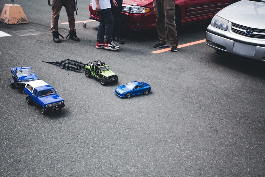 Model cars parked beside a full-size car, showing the difference in size