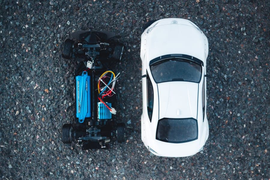 Two electric RC cars seen from above on asphalt